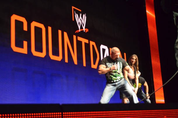 Triple H on stage with Stephanie McMahon. 2013 Binh Nguyen for SideQuesting